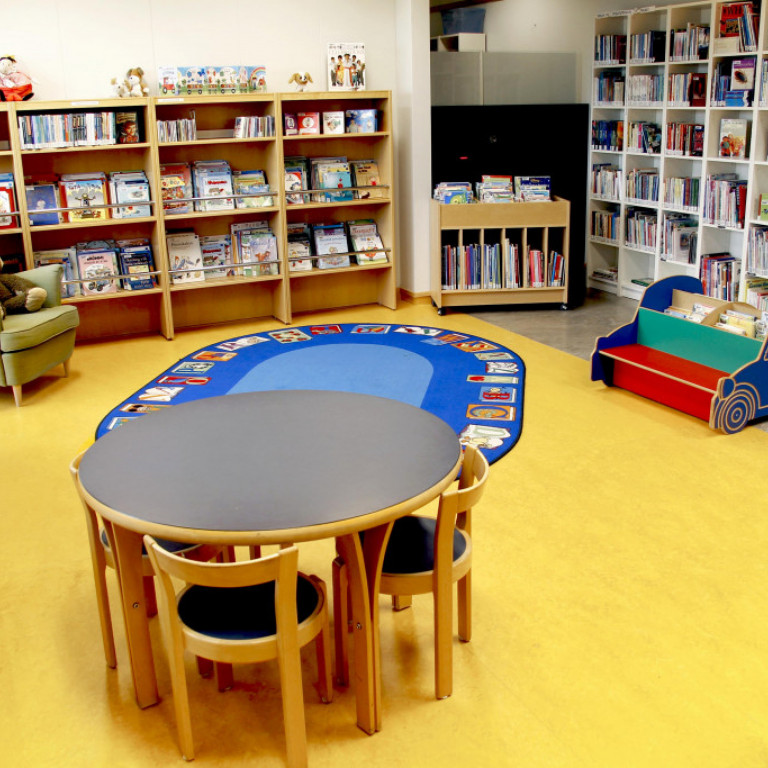 Aðstaða fyrir börn með leikmottu, notalegum lesstól, stólum og borði